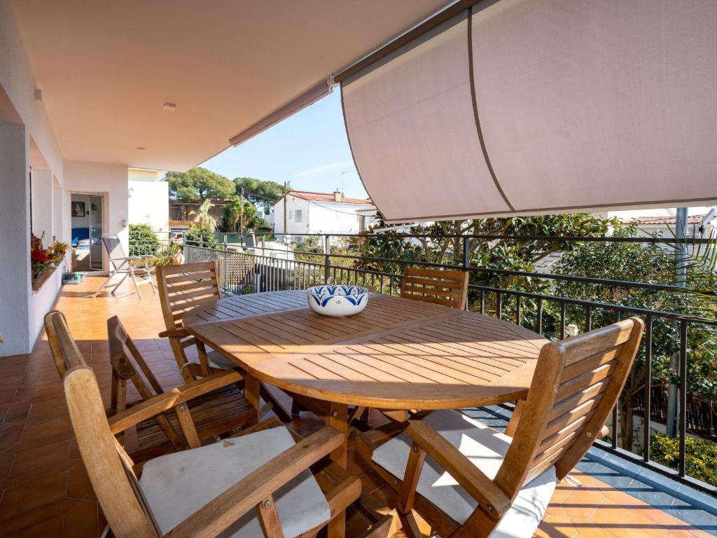 a wooden table and chairs on a balcony at Apartment Millenium by Interhome in Premia de Dalt