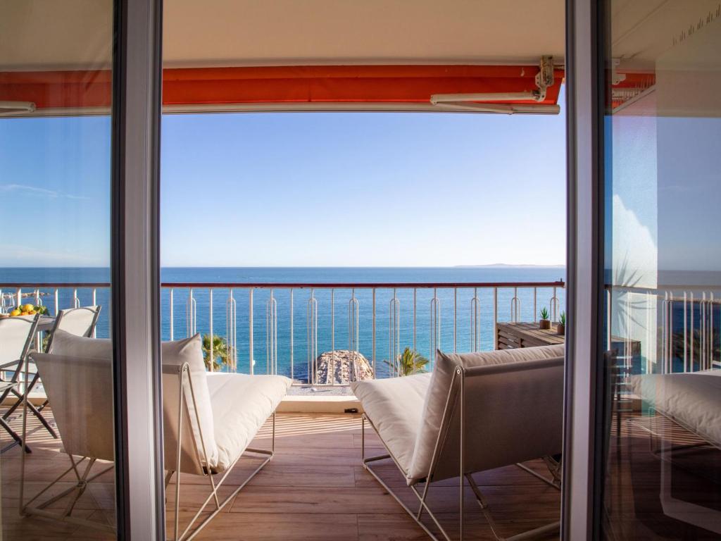 d'un balcon avec des chaises et une vue sur l'océan. dans l'établissement Apartment L'Angelina-2 by Interhome, à Cagnes-sur-Mer