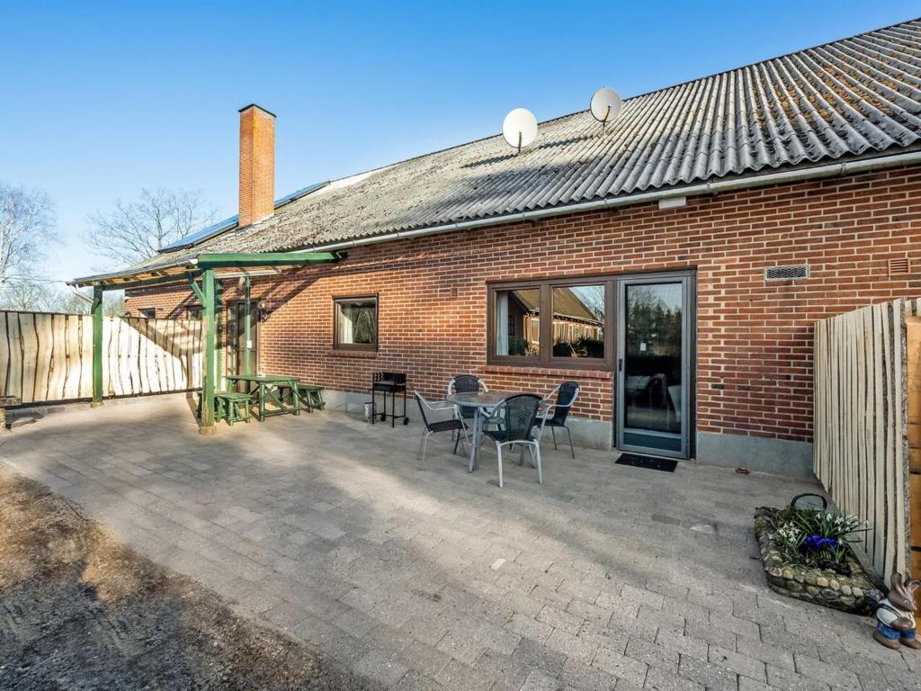 a brick house with a patio with a table and chairs at Apartment Evina - 17km to the inlet in Western Jutland by Interhome in Skjern