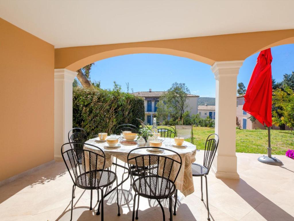 un patio avec une table et des chaises sur un porche dans l'établissement Apartment Le Domaine de Figuière-2 by Interhome, à Sainte-Maxime