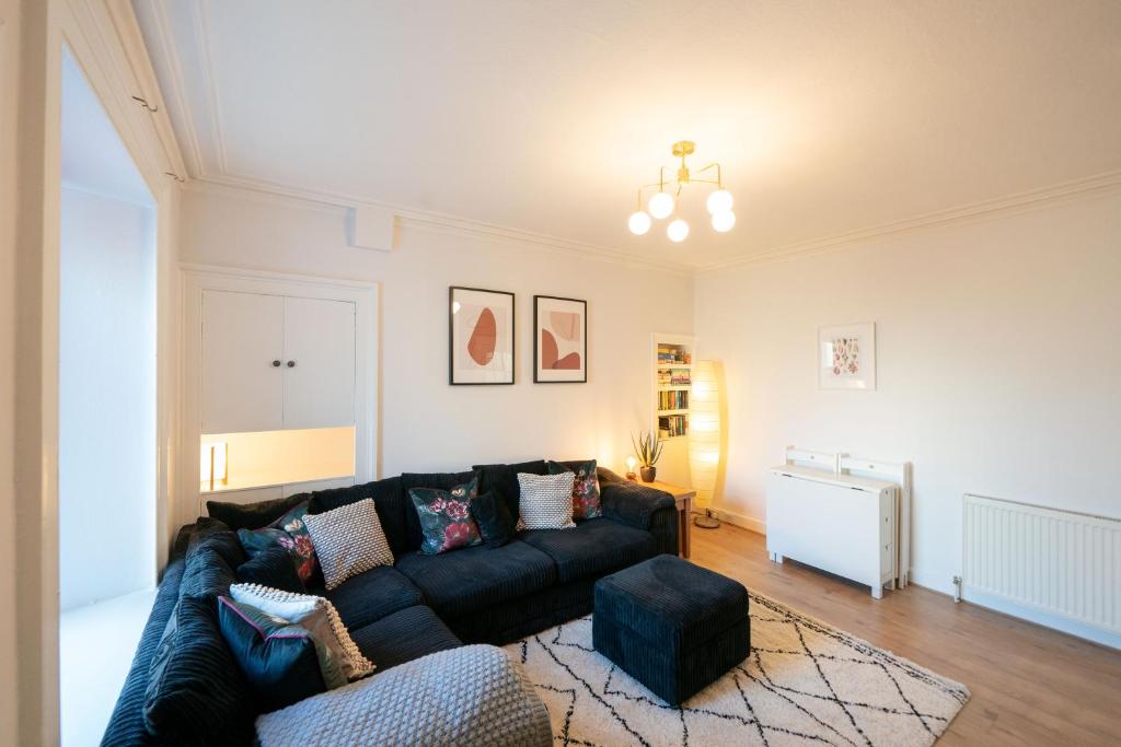 a living room with a black couch and a rug at Seaside Home in Stonehaven, Aberdeenshire in Stonehaven