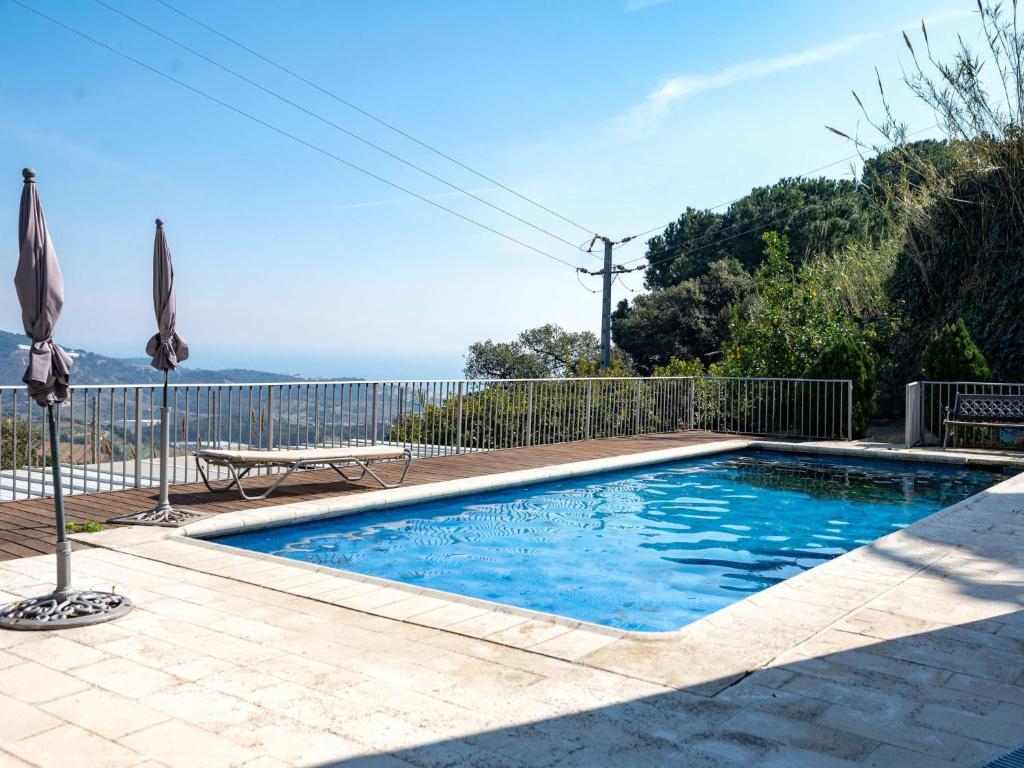 een zwembad in een tuin met een hek bij Apartment Irule by Interhome in Sant Cebrià de Vallalta