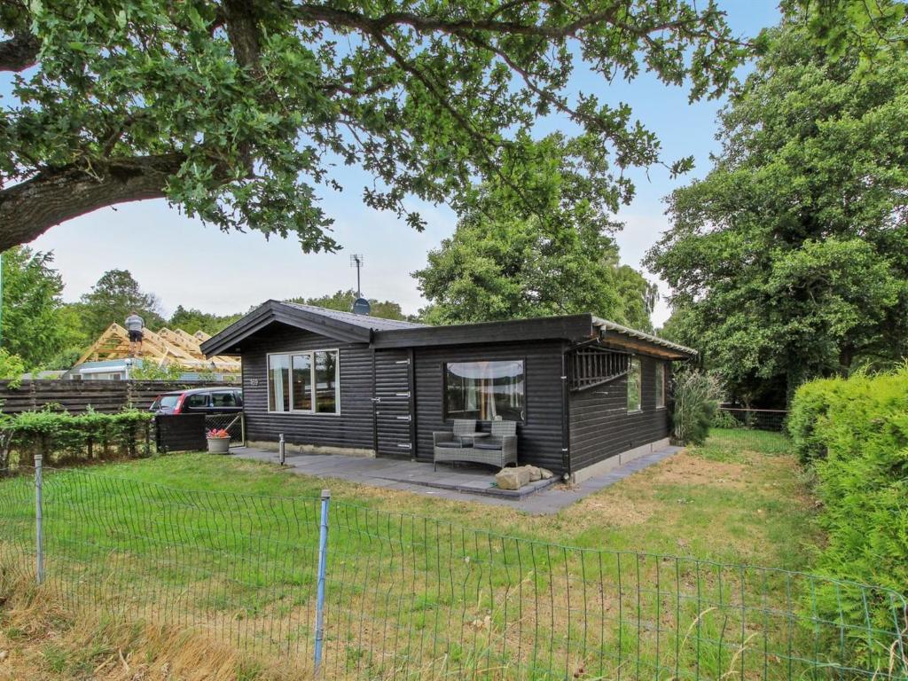 een klein zwart huis met een tuin bij Holiday Home Graa in SE Jutland by Interhome in Skanderborg