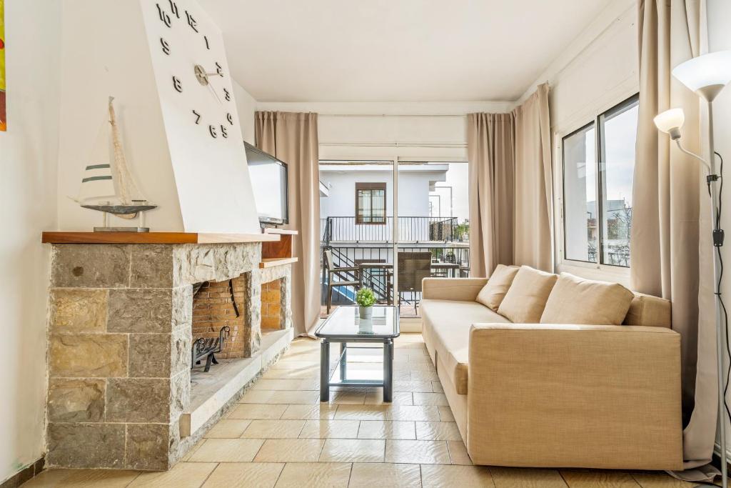 een woonkamer met een bank en een open haard bij La Marina Apartments in Platja  d'Aro