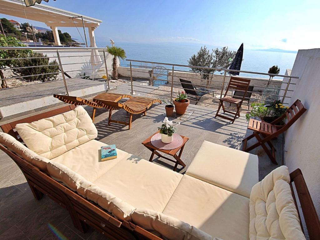 ein Wohnzimmer mit einem Sofa, Stühlen und Meerblick in der Unterkunft Apartment Borka-3 by Interhome in Trogir