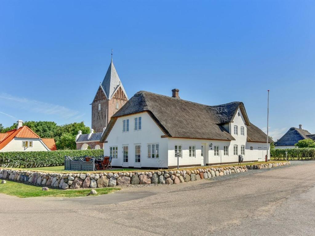 una gran casa blanca con una iglesia en el fondo en Holiday Home Ejna in Western Jutland by Interhome, en Bredebro