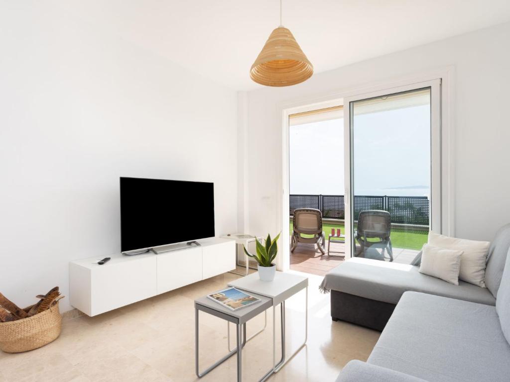 A television and/or entertainment centre at Apartment Playa Negra II by Interhome