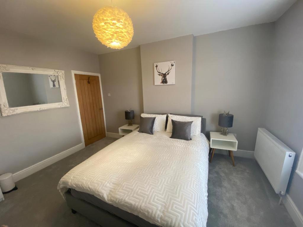 a bedroom with a large bed and a chandelier at Amazing Two Bedroom Apartment - SR in Southport