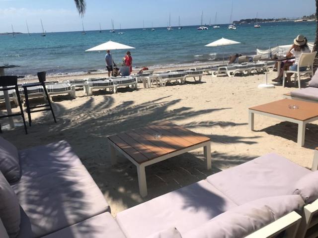 une plage avec des tables et des chaises et l'océan dans l'établissement BANDOL ROC BEACH VUE MER Grand T3 face à la plage avec parking, à Bandol