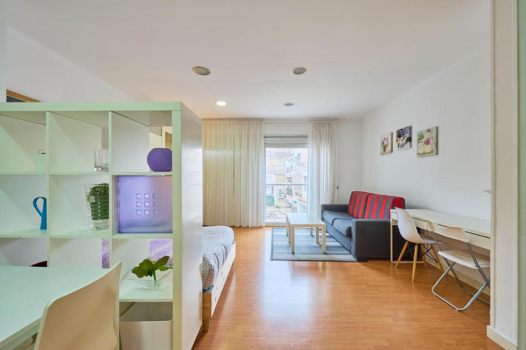 een woonkamer met een bank en een tafel bij Precioso Loft en Badalona Centro in Badalona