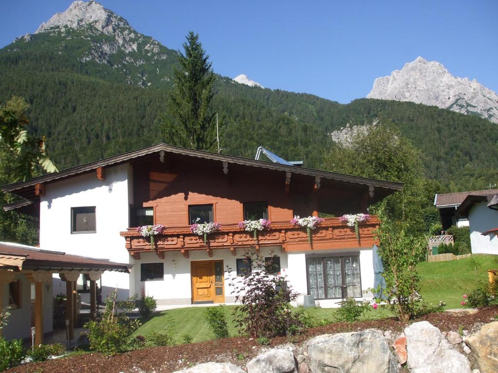 a house in the mountains with mountains in the background at Haus Wittig in Sankt Ulrich am Pillersee