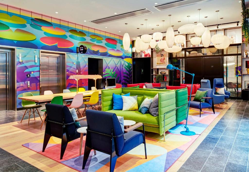 a lobby with a colorful couch and chairs at citizenM Paris Opera in Paris