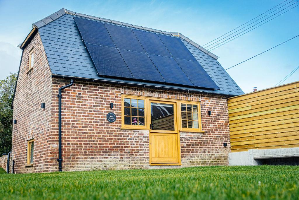 una casa con paneles solares encima en The Stable, en Canterbury