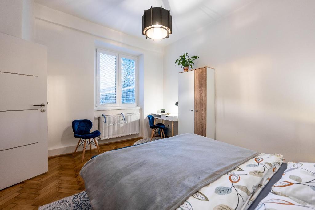 a bedroom with a bed and two chairs and a desk at Mojmirova Apartment Kosice Center in Košice