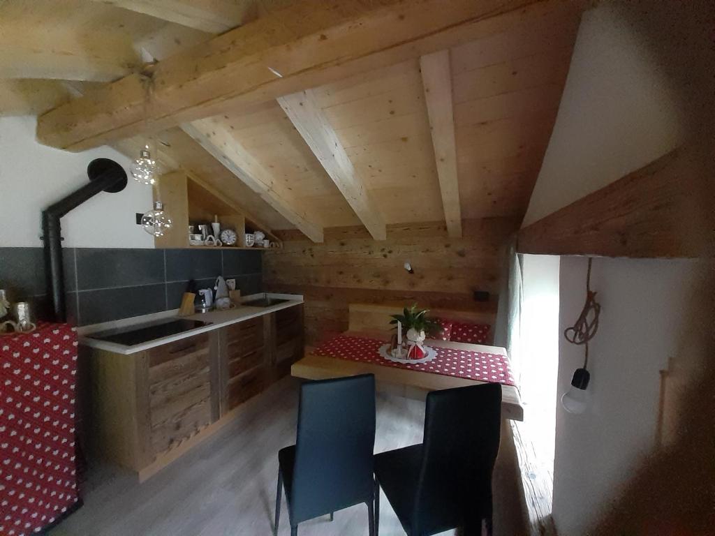 una cocina con armarios de madera, mesa y sillas en CASERA ONORINA Val Visdende, en Santo Stefano di Cadore