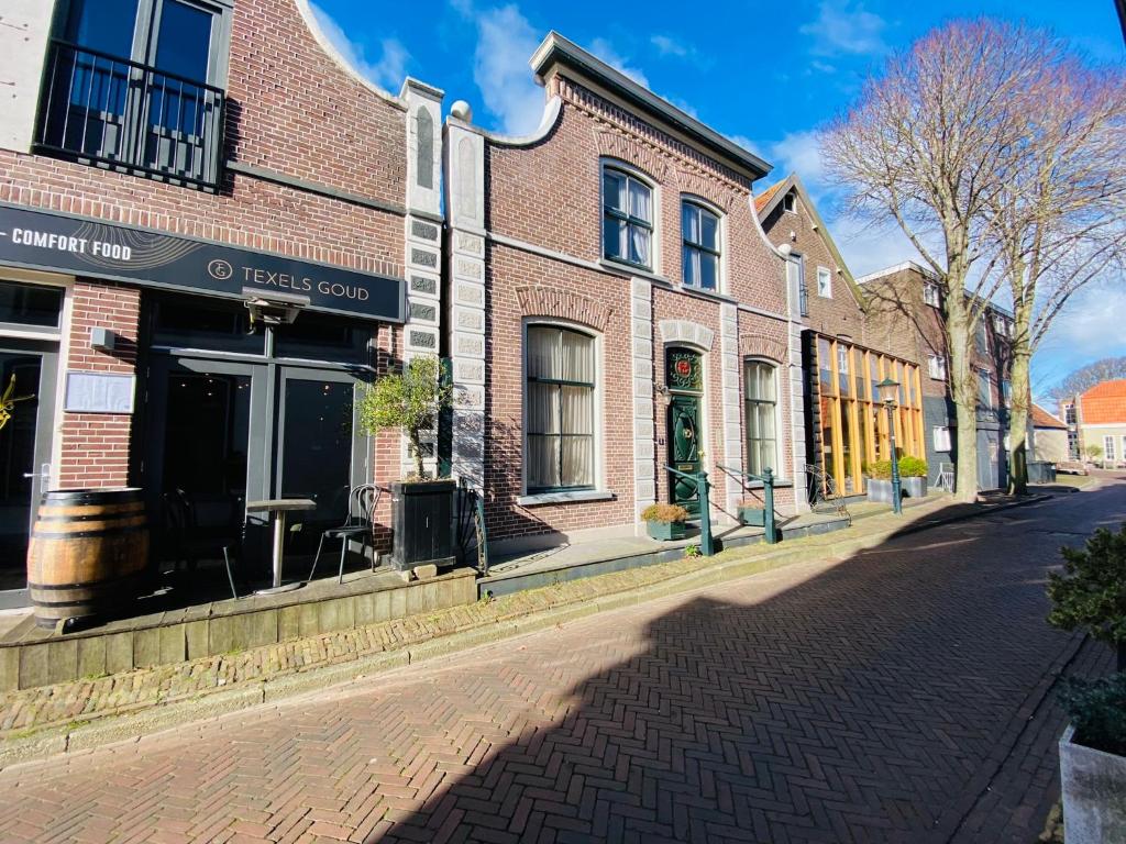 The island life Texel في دن بورخ: شارع فيه مبنى من الطوب على شارع