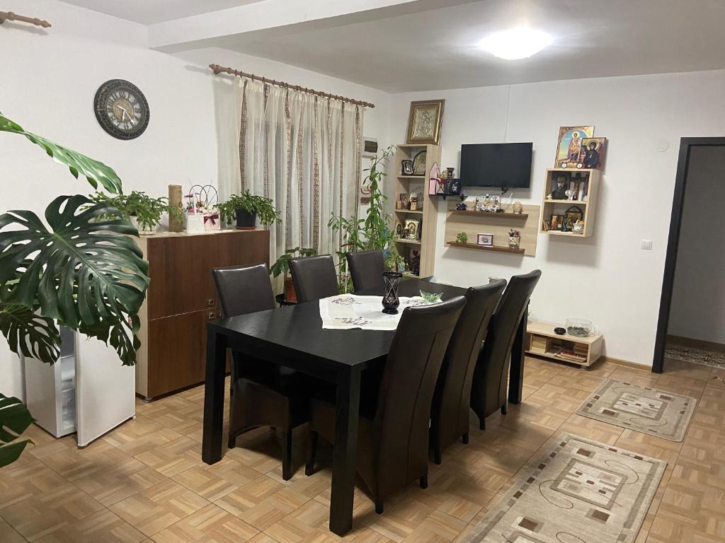 a dining room with a black table and chairs at Pensiunea Maria și bunicii in Tulcea