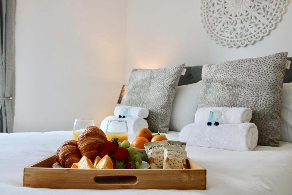 a tray of bread and fruit on a bed at Cicero Fairfields by Pay As U Stay in Milton Keynes