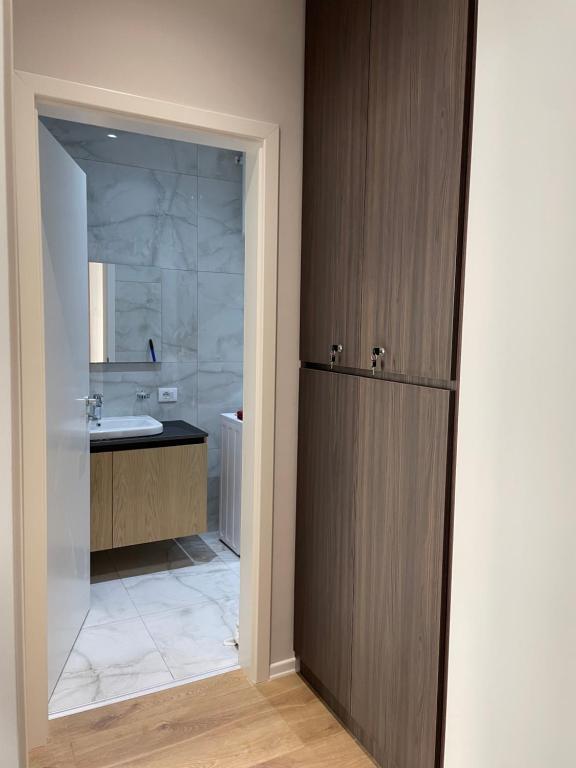 W łazience znajduje się umywalka, toaleta i lustro. w obiekcie NEW Brilant Apartment w Tiranie