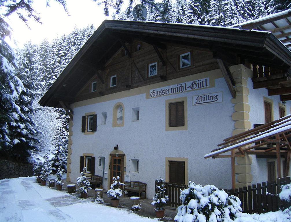 a building with a sign on it in the snow at Gassermühle-Ferienhaus in Eggen