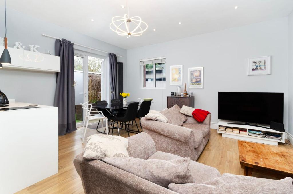 sala de estar con sofá, TV y mesa en Charming Ground Floor 1 Bedroom Flat in Twickenham, en Twickenham