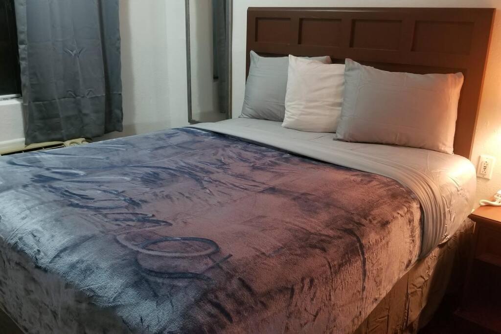 een slaapkamer met een bed met een schilderij erop bij OSU King AC WI-FI Hotel 206 Booking in Stillwater