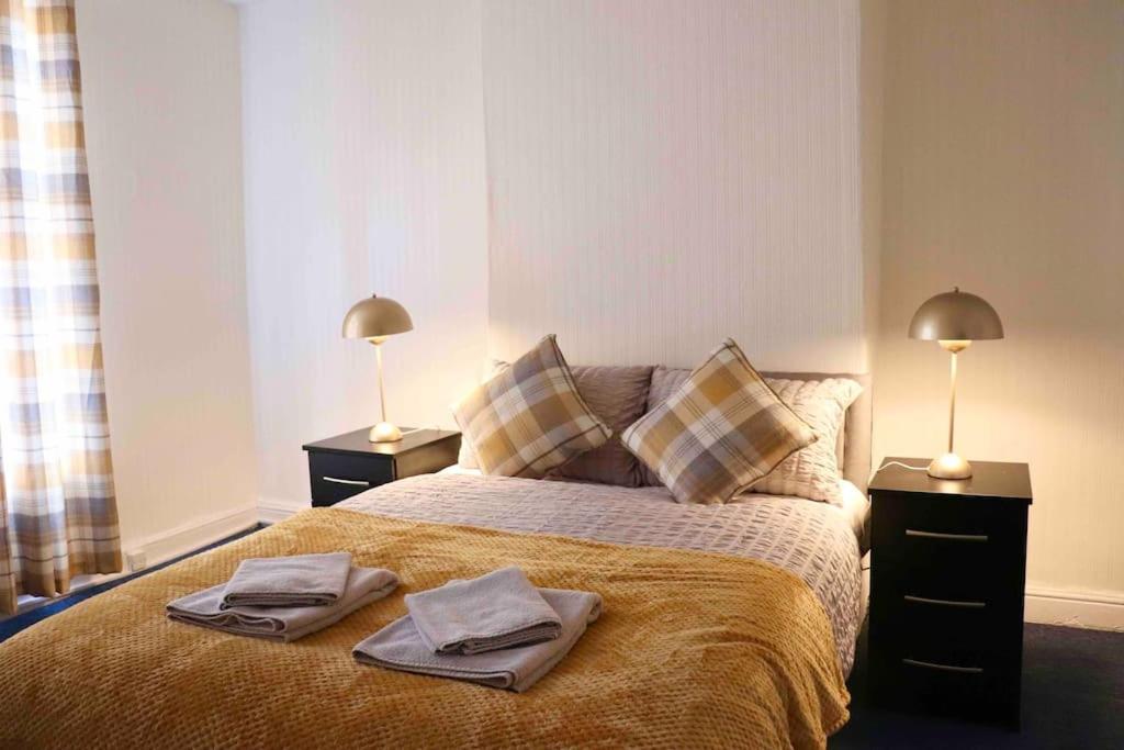 a bedroom with a bed with two lamps and towels on it at Peaceful 2 Bed House FREE WiFi and Parking in Belle Isle