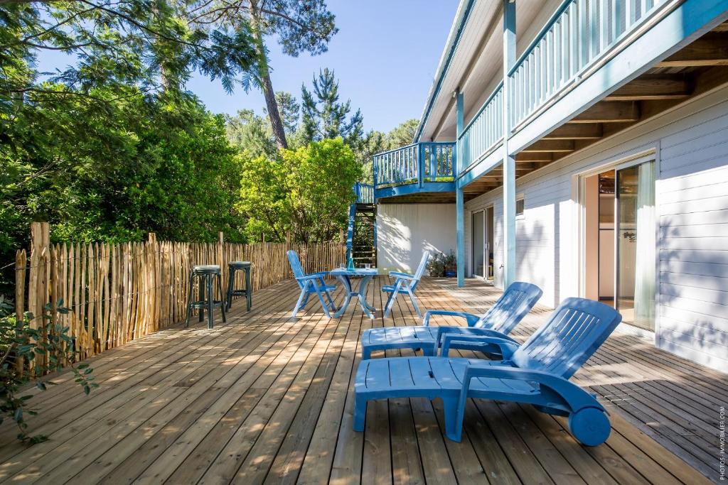 une terrasse avec des chaises et des tables bleues sur une maison dans l'établissement La Villa Bleue, à Lège-Cap-Ferret