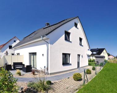 uma grande casa branca com um telhado preto em Ferienhaus Wellenreiter em Zierow