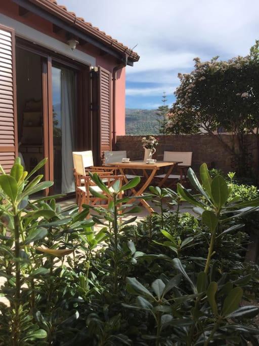eine Terrasse mit Tisch und Stühlen an einem Haus in der Unterkunft Eva's cottage Kastelli Pediados in Kardhoulianós