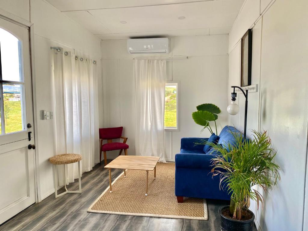 a living room with a blue couch and a table at Rancho Dominique Valle de Guadalupe in Valle de Guadalupe
