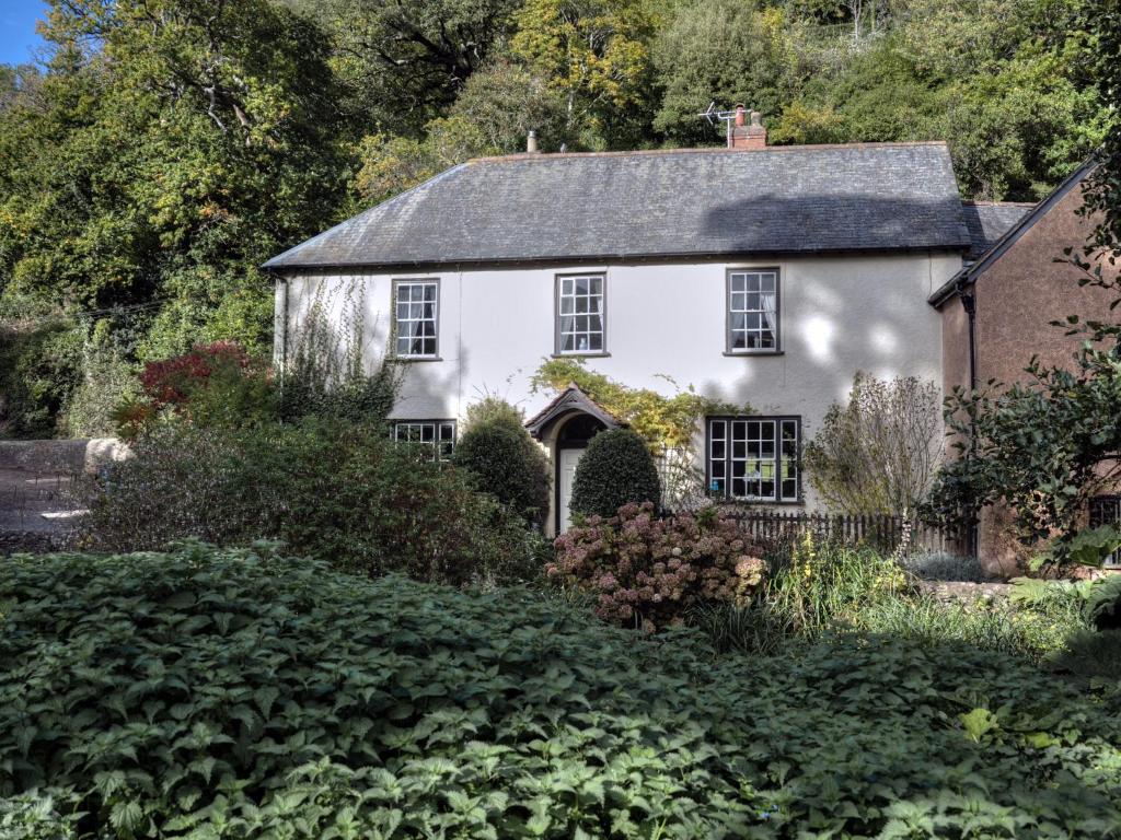 een oud wit huis in de tuin bij Dunster Mill House in Dunster