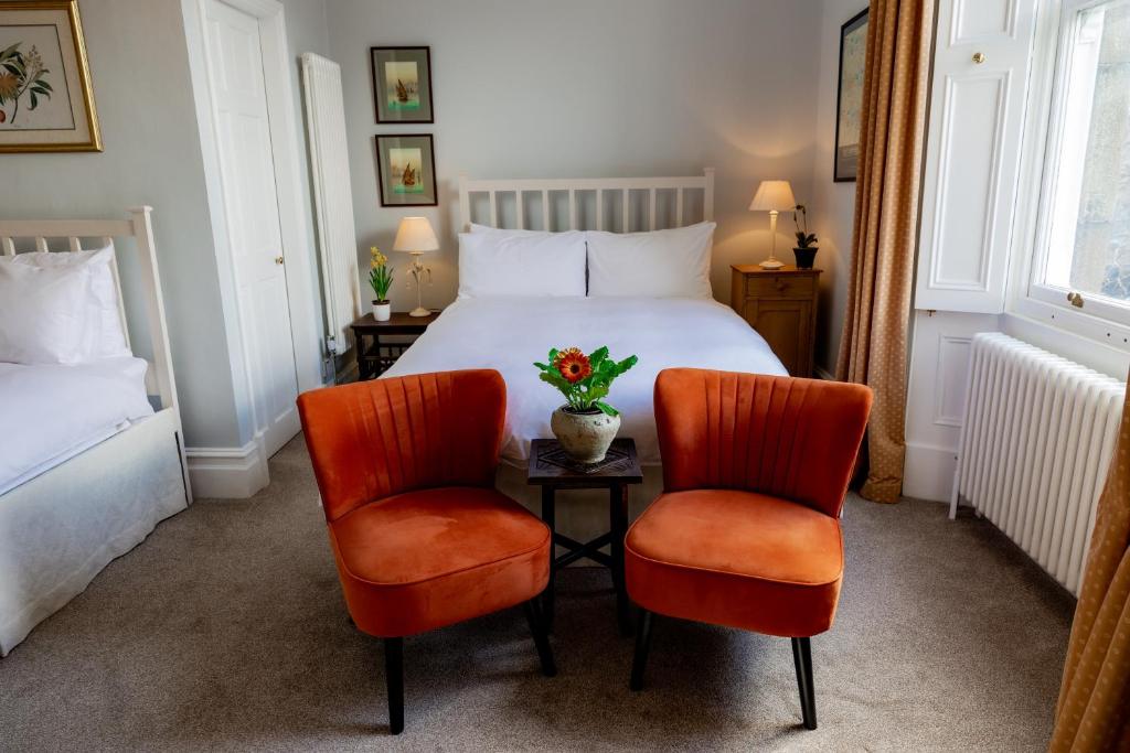 a hotel room with a bed and two chairs at Newgate House in Barnard Castle