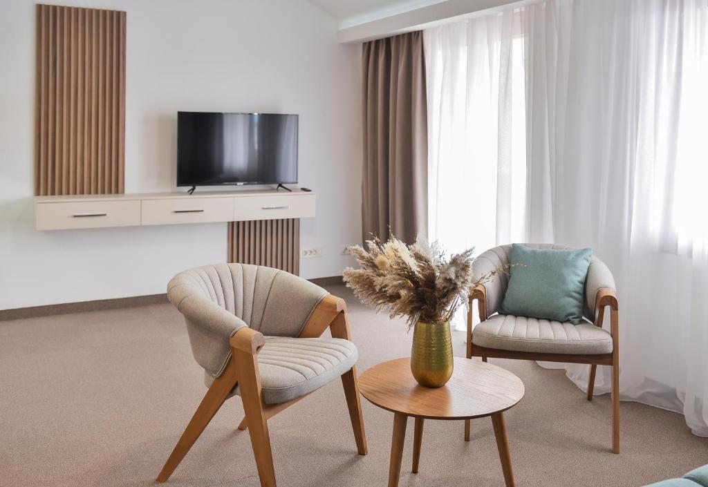 ein Wohnzimmer mit 2 Stühlen und einem TV in der Unterkunft Magnolia Place in Tivat