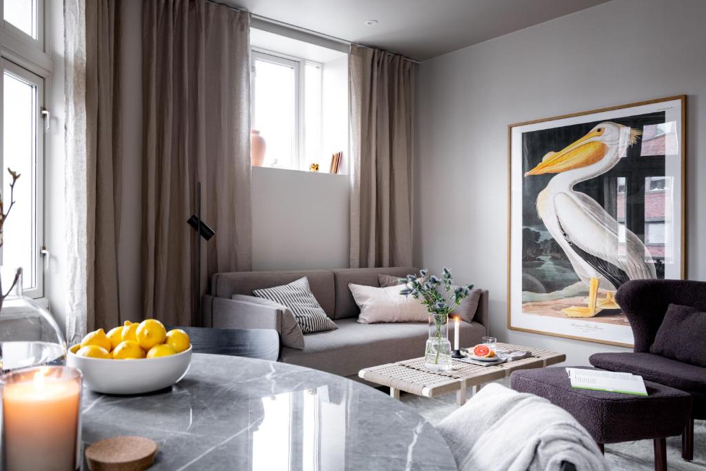 a living room with a table and a bird painting at Hotel suite apartment in Oslo