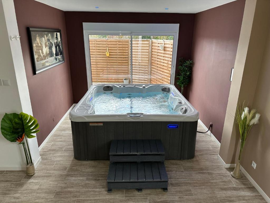 a large hot tub in a room with a window at Victory Lodge spa in Choisy-la-Victoire
