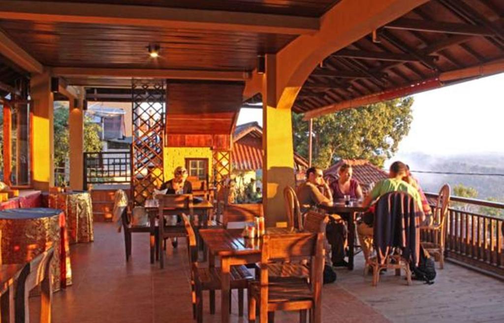 a group of people sitting at tables in a restaurant at Guru Ratna in Munduk