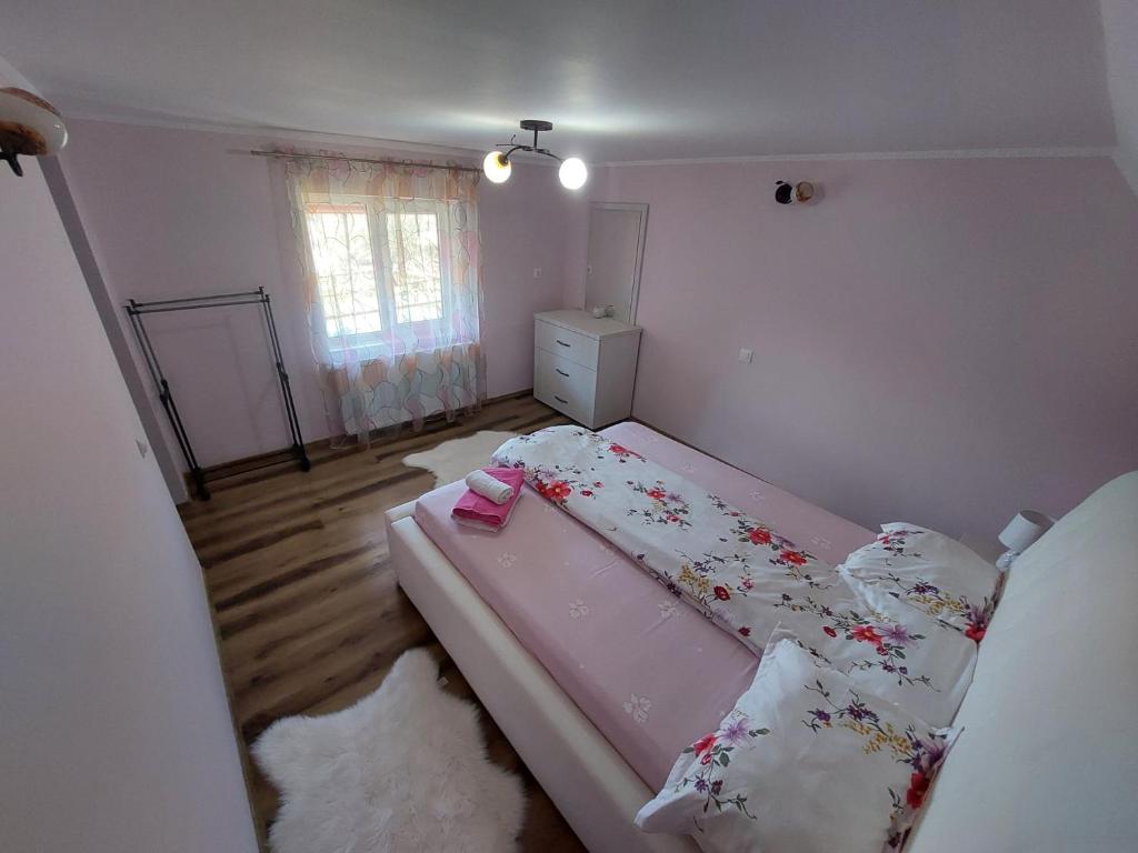 - une petite chambre avec un lit rose dans l'établissement Casa Bucium, à Bucium