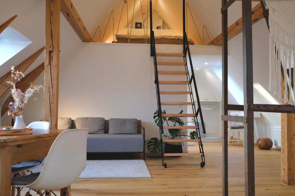ein Loft mit einer Treppe in einem Zimmer mit einem Sofa in der Unterkunft Helles modernes City-Loft in Freudenstadt