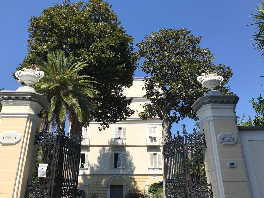 une porte en face d'un bâtiment planté de palmiers dans l'établissement Villa Falconieri Sorrento Suite, à Sant'Agnello