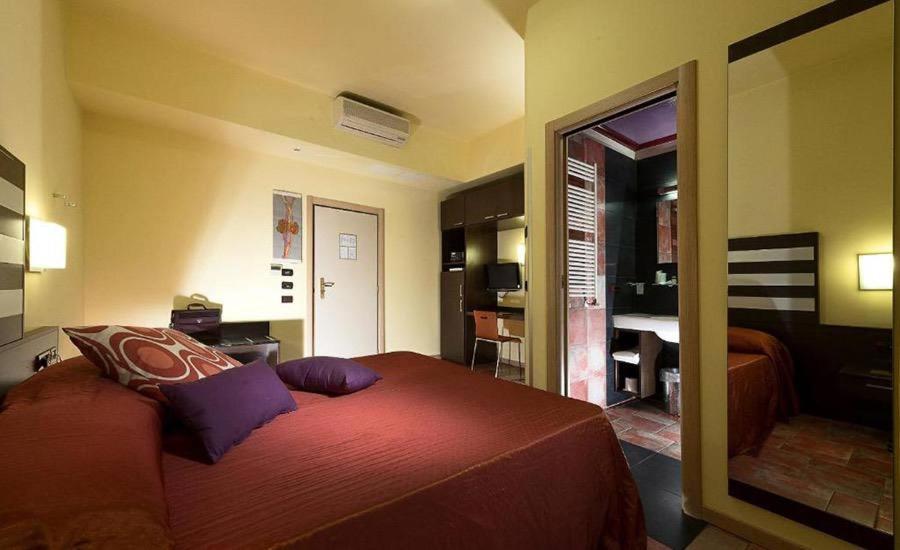 ein Schlafzimmer mit einem Bett und ein Wohnzimmer in der Unterkunft Hotel Garden Bologna in Crespellano