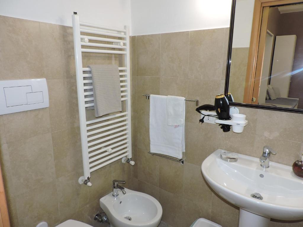 un bagno con lavandino, water e specchio di Monolocale Via Cerquiglia, 136 a Spoleto