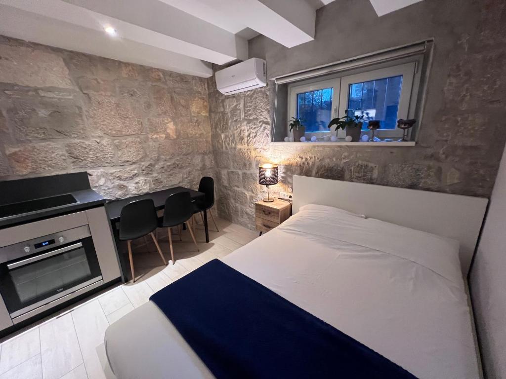 a bedroom with a bed and a table and a tv at Center Beach Apartament, Split, Croatia in Split