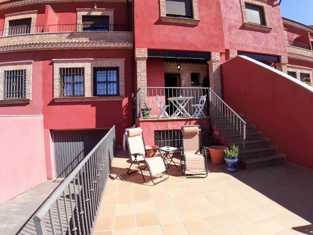 dwa krzesła i stół na balkonie budynku w obiekcie Casa grande de tres plantas w mieście Linares