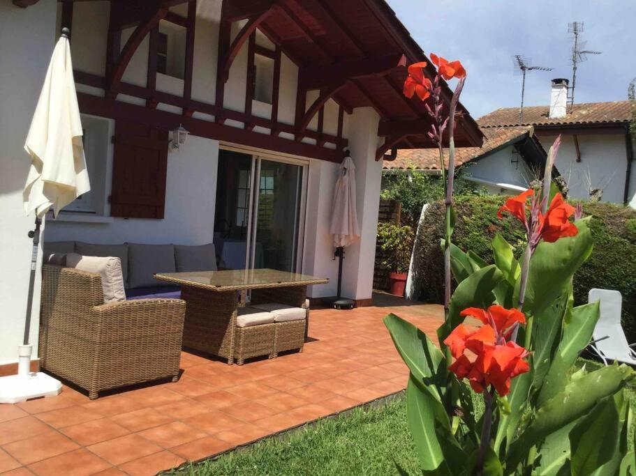 a patio with a table and chairs and an umbrella at 1km plage, agréable maison 6 pers classée 3* in Hendaye