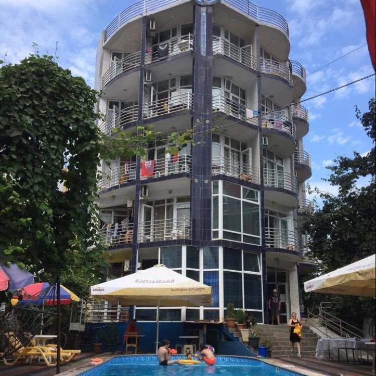 a large building with a swimming pool in front of it at Family hotel Khomaldy in Kvariati