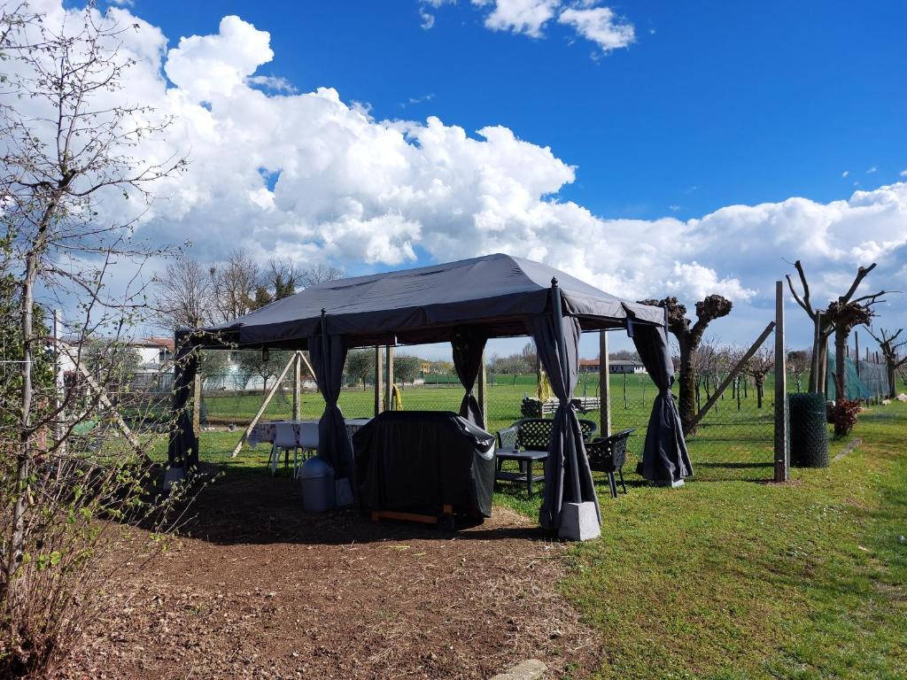 ein schwarzes Zelt mit einem Tisch und Stühlen auf einem Feld in der Unterkunft Stunning 3-Bed House in San Zenone degli Ezzelini in San Zenone