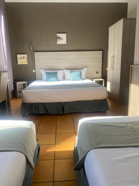 Cette chambre d&#39;hôtel comprend 2 lits avec des oreillers bleus. dans l&#39;établissement Les Lavandes, à La Ciotat
