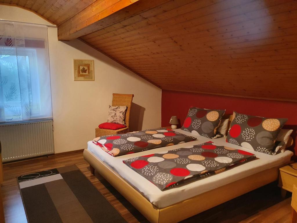 a bedroom with a large bed and a chair at Ferienwohnung Langdorf in Langdorf im Landkreis Regen