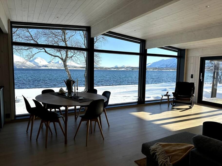 a living room with a table and a view of the water at Cabin in Tromsø in Tromsø